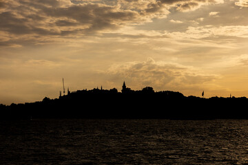 Fototapeta premium Dramatic Istanbul skyline silhouette with mosque minarets and domes at golden sunset