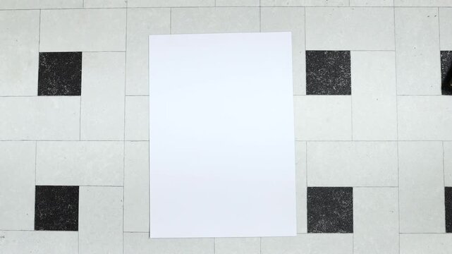 Person holding white empty paper A4 on tiles backdrop