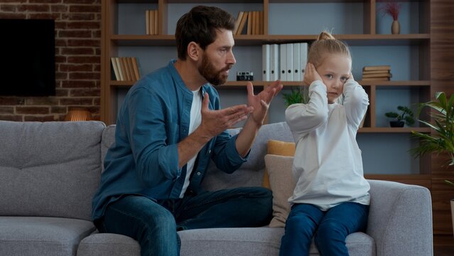 Caucasian family quarrel agressive father talk shouting to frustrated daughter closing covering ears domestic violence punishment dad scolding unhappy little child kid girl suffering conflict problem - Powered by Adobe