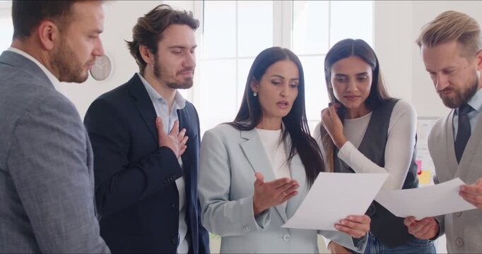 Business people team collaborates in an office meeting, working together on documents to plan and strategize. The focus is on teamwork, collaboration, and achieving company goals efficiently.