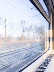 View of the railway track and trees from the window of a train at high speed. Winter train journey.