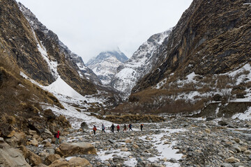 A group of people are trekking a rocky path in the Himalayas toward Annapurna Base Camp, Nepal....