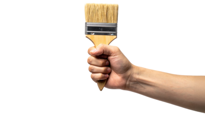 A person's hand holding a paintbrush, ready to create. The tool held firmly
