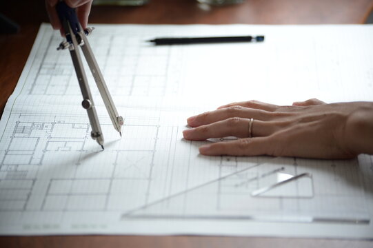 建築士が製図作業を行う手元　コンパスを使った建築設計図の作成
An architect working on a drawing