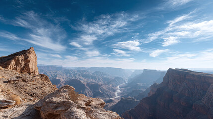 Breathtaking vista of a deep canyon under a vast blue sky. Eroded cliffs frame a winding river. Majestic landscape. Ideal for travel, nature, or environmental themes.