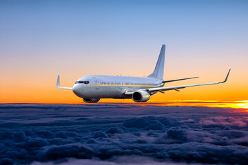 White passenger airplane fly in the sunrise sky