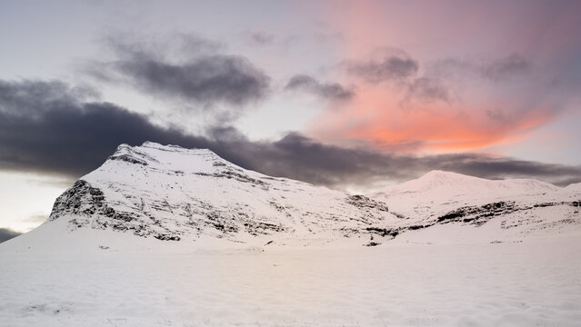 Fototapeta View of snow-capped mountain peaks under a bright sunrise sky. The white snow contrasts beautifully with the clear sky. Beautiful landscape for a natural or winter background or wallpaper