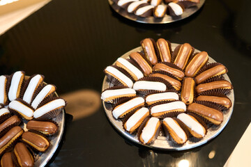Assorted Mini Éclairs with Chocolate and Vanilla Glaze on Silver Tray