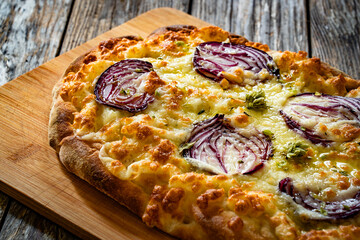 Pinsa bianca white pizza with red onion and oregano on wooden table