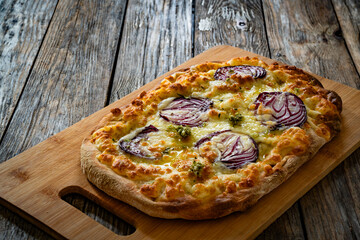 Pinsa bianca white pizza with red onion and oregano on wooden table