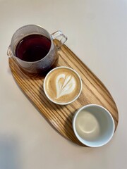 Filter coffee maker and cup of cappuccino on wooden table, cozy morning coffee scene.
