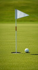 Obraz premium A close-up shot of a white triangular pennant flag flying atop the pin marking the golf hole on a perfectly manicured green under sunlight ,destination ,landscape ,leisure