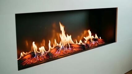 Modern electric fireplace with orange flames. Fire heating system inside minimalist white wall. Cozy home decor element video.