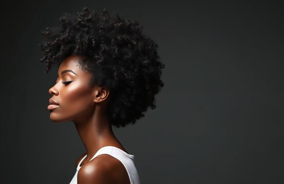 Portrait of afro black model in profile with beautiful hair. Woman presents shiny skin, perfect makeup. Haircut illustration concept for salon. Beauty fashion portrait. Trendy hairstyle on dark