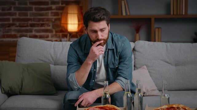 Caucasian middle-aged frustrated disappointed man at home party canceled with pizza chips stress alone lonely male guy on couch suffering without no friends birthday loneliness isolation quarantine