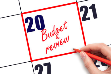 20 th day of the month.  Hand writing Budget review reminder and drawing red frame on calendar with...