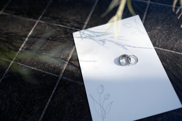 a couple of wedding put on the white blank paper card in sun shine and shade of branches