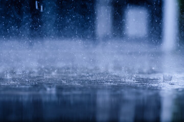 heavy raining make many small splash crown from water droplets drop down to the concrete floor in blue tone color scene