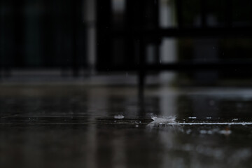 heavy raining make many small splash crown from water droplets drop down to the concrete floor in blue tone color scene