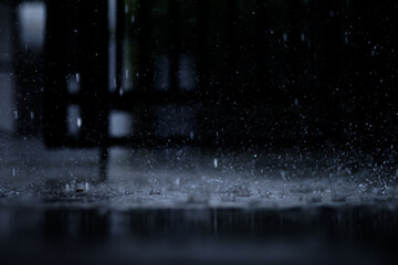 heavy raining make many small splash crown from water droplets drop down to the concrete floor in blue tone color scene