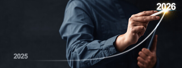 Business hand with tablet slides the ascending line from 2025 to 2026 on a virtual screen. Happy...