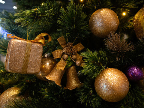 close upe of gold gift box on christmas tree