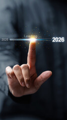 Business hand slides the loading bar from 2025 to 2026 on a virtual screen. Happy New Year concept or Celebration