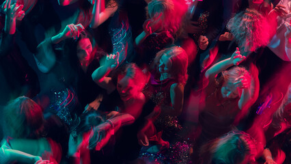 Festive night dance with motion blur and glowing pink-blue light. Concept of event marketing, digital lifestyle celebration, and expressive youth joy