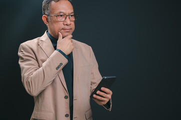 Mature Businessman Thoughtfully Holding Smartphone, Engaged in Digital Strategy and Communication