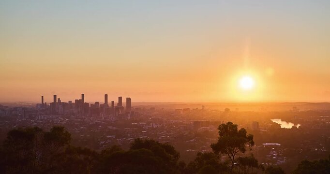 4K locked off stationary Time Lapse motion view of Brisbane Central Business District at dawn with the rising sun in background, Brisbane, Queensland, Australia