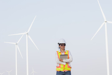 A confident engineer stands among wind turbines, showcasing sustainable energy solutions for a greener future.