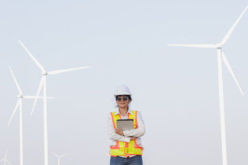 A confident engineer stands amidst towering wind turbines, showcasing renewable energy innovation and sustainable development.