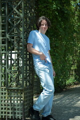 Fototapeta premium Male Individual in Casual Clothing Adjacent to Trellis Framework
