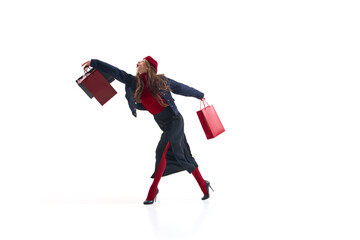 Fashion woman in red and navy outfit walking gracefully with shopping bags in motion. Concept of elegant lifestyle, retail energy, modern fashion expression for editorial and advertising use.