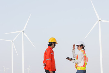 Two workers discussing wind turbine installation in a renewable energy field, demonstrating teamwork and innovation in clean energy.