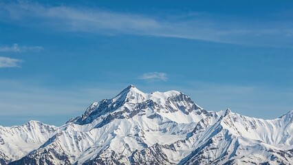 The snow-capped mountain stands tall against a clear blue sky, its jagged peaks and pristine snow reflecting the beauty and power of nature