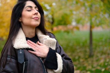 Relaxed woman breathing fresh air outdoor in the autumn 
