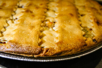 Macro close-up of a pie with lattice and golden brown crust. Baking banner, background or design element. Holiday atmospheric mood.