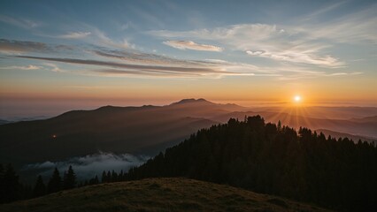 Mountain sunrise over rolling hills and forested mountains at dawn.