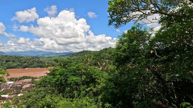 Aerial view from Mount Phousi overlooking Luang Prabang, Laos - spring day with sunshine and clouds over the Mekong River and city landscape.