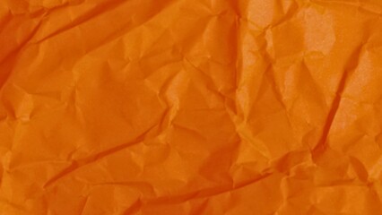 Textured orange fabric with deep folds and shadows