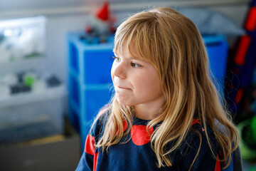 Portrait of a cute little girl playing pc video game. Happy smiling preschool child laughing. Childhood concept.