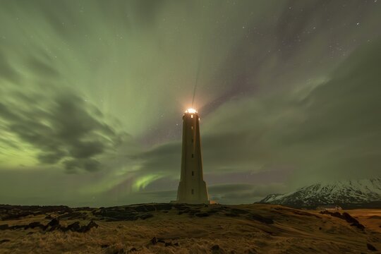 Northern lights or aurora borealis, lighthouse sends light signal, Malarr&iacute;f, Sn&aelig;fellsnes Peninsula, Sn&aelig;fellsj&ouml;kull National Park, Iceland