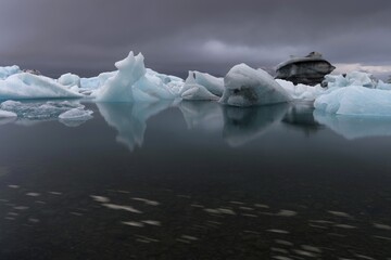 Icebergs under dark clouds, dramatic and threatening, long exposure, glacier lagoon Jökulsárlón or Jökulsarlon, South Iceland, Iceland