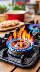 A black stove burner with a red flame. The stove top is on a table