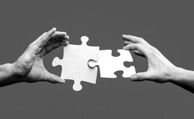 Closeup hands of man connecting jigsaw puzzle. Business solutions, success and strategy concept. Two hands trying to connect couple puzzle. Businessman hand connecting jigsaw puzzle
