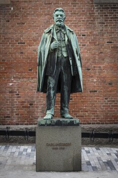 Bronze statue of Carl Jacobsen, Danish brewery entrepreneur, art collector and benefactor, in front of brick wall on plinth, Carlsberg district, Copenhagen, Denmark