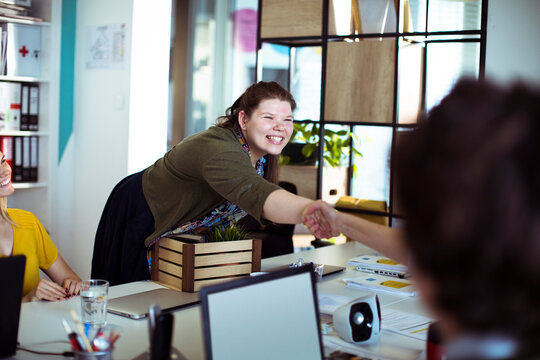 Young woman shaking hands in office