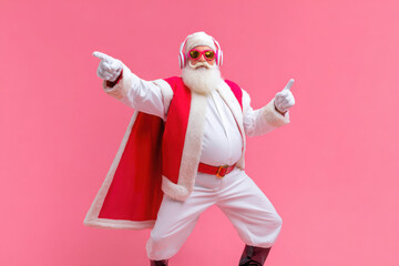 Photo of funky cool big abdomen santa claus enjoy listen headphones x-mas christmas songs radio raise fingers dance wear sunglass suspenders headwear isolated over pastel color background