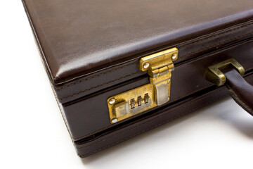 A vintage brown leather suitcase with gold latches isolated on a white background. This suitcase is usually used for business trips.
